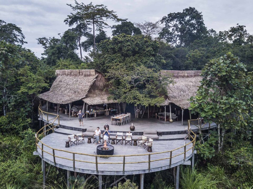 Vista frontal del Lango Lodge con fogata y zona común en Odzala-Kokoua (República del Congo).
