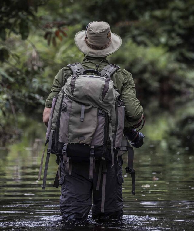 Explorador cruzando un arroyo durante una caminata en Odzala-Kokoua (República del Congo).